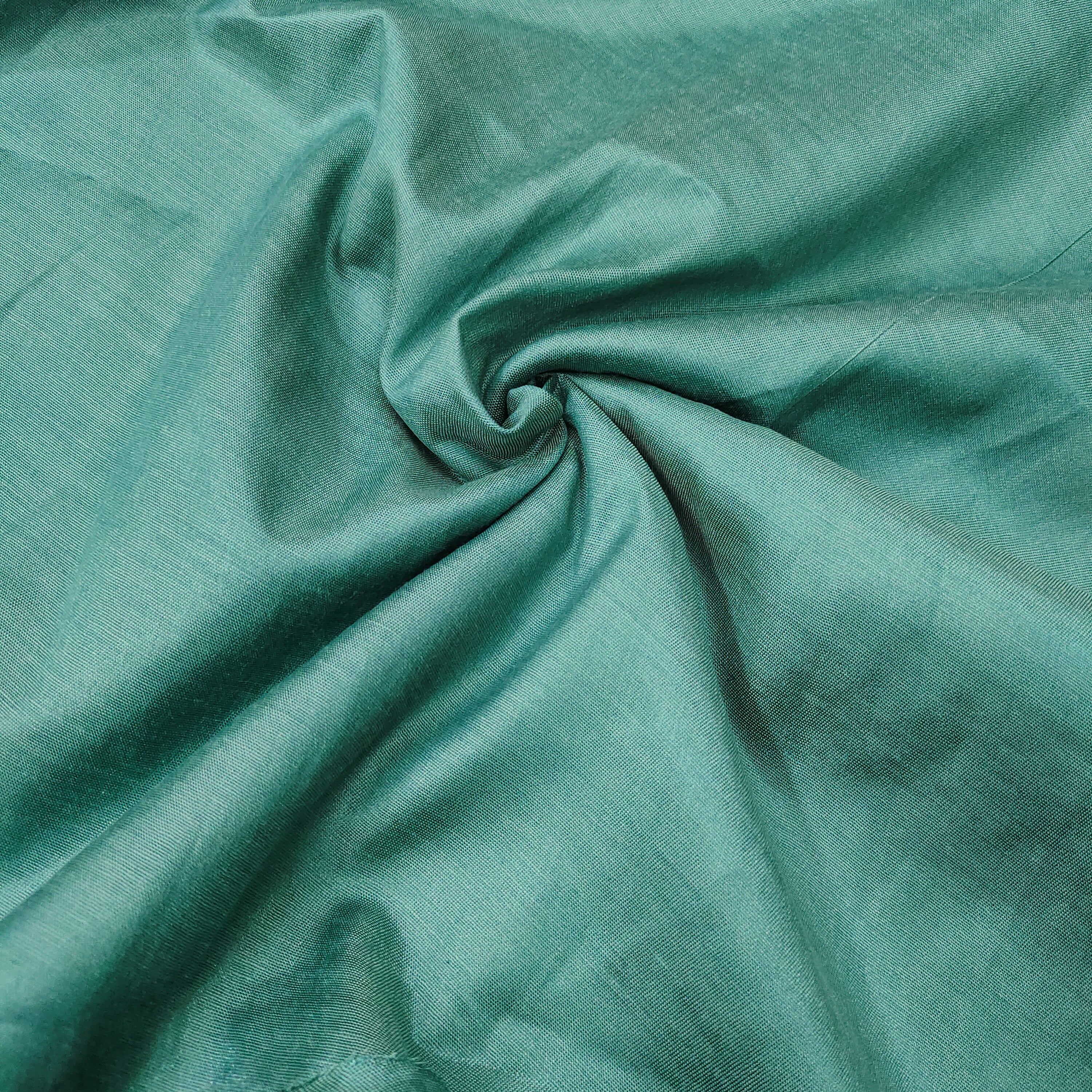 Close-up of teal fabric with folds