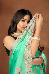 light green embroidery saree with floral patterns and a dark green blouse piece